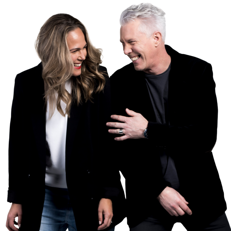 A man and woman stand side by side, both smiling and laughing. They are wearing dark jackets, and seem to be enjoying a friendly moment together—meet the Humanico team behind this warm camaraderie. | Humanico Workforce Intelligence Software