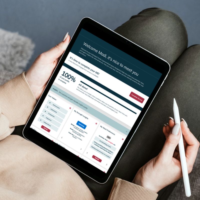 A person holding a tablet and stylus, viewing the Humanico demo dashboard displaying 100% completion status and various completed sections. Seated with legs crossed, they wear neutral-colored clothes. | Humanico Workforce Intelligence Software