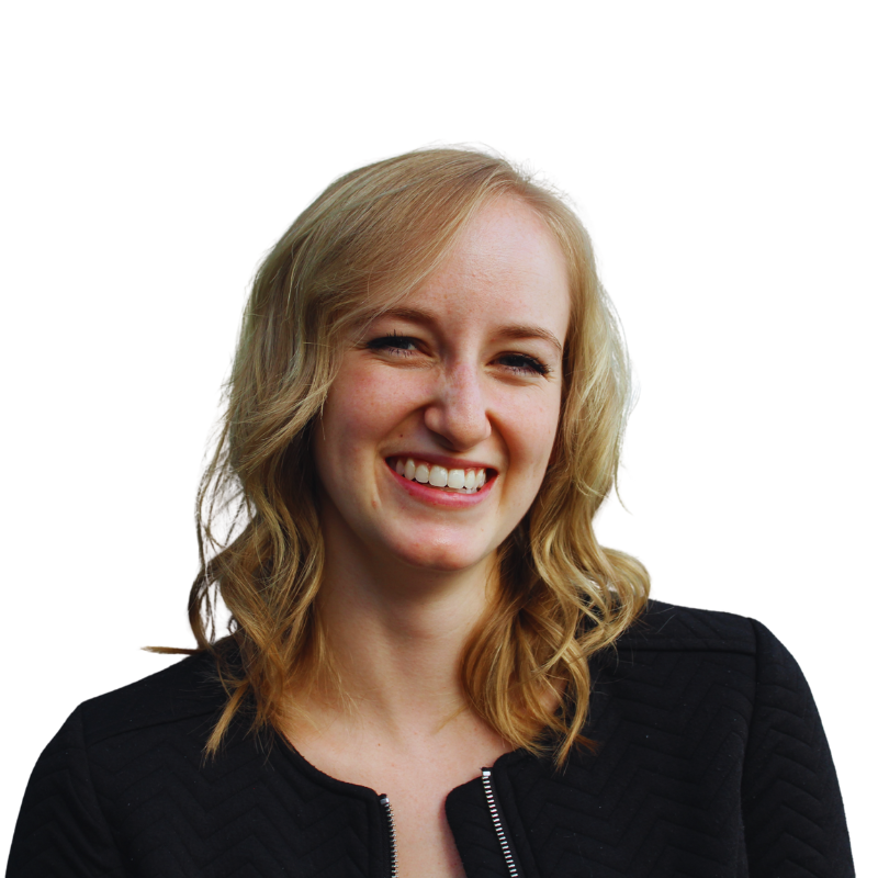 A woman with wavy blonde hair wearing a black textured jacket is smiling and looking slightly to the right against a plain background, showcasing confidence perfect for a humanico demo. | Humanico Workforce Intelligence Software