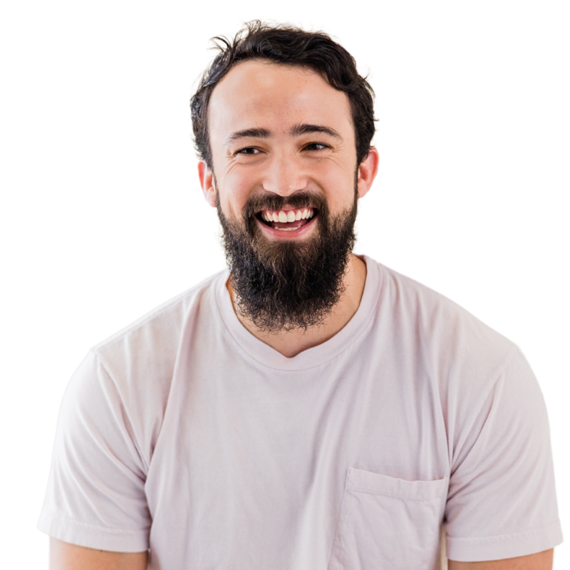 A bearded man with dark hair, wearing a light pink t-shirt, smiles broadly while looking slightly to the side—capturing the approachable spirit of today’s workforce intelligence founders. | Humanico Workforce Intelligence Software