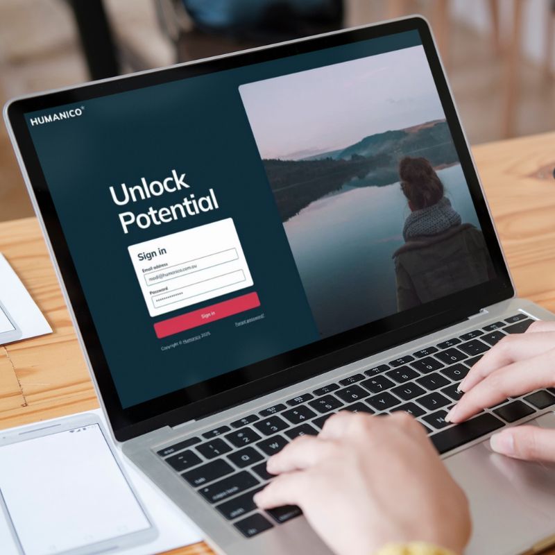 A person typing on a laptop displaying a login page titled "Unlock Potential," featuring a sign-in form and an image of someone overlooking a calm lake—showcasing how HR software can enhance employee retention. | Humanico Workforce Intelligence Software