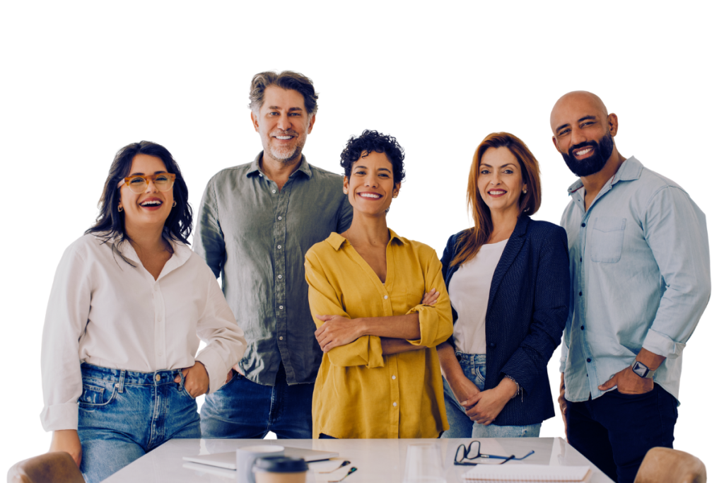 Five people stand together smiling in a casual office setting, dressed in business casual attire. In the foreground are a desk, laptop, notebook, and coffee cup—capturing the spirit of the workforce intelligence founders at work. | Humanico Workforce Intelligence Software